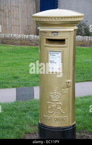 Golden postbox. Royal Mail pilastro scatola dipinta in oro e dedicato a Helena Lucas, un 2012 Paralimpico campione di vela. Isola di Portland, Dorset, Regno Unito. Foto Stock