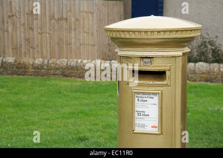 Golden postbox. Royal Mail pilastro scatola dipinta in oro e dedicato a Helena Lucas, un 2012 Paralimpico campione di vela. Isola di Portland, Dorset, Regno Unito. Foto Stock