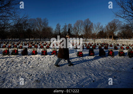 Ottawa. Il 7 dicembre, 2014. Un uomo cammina tra gli oggetti contrassegnati per la rimozione definitiva durante l annuale ghirlande di tutto il Canada commemorazione presso il National Cimitero militare di Ottawa in Canada il 7 dicembre, 2014. Circa 3 mila corone sono state poste sulle tombe dei soldati, marinai e piloti che hanno servito in Canada. Credito: David Kawai/Xinhua/Alamy Live News Foto Stock