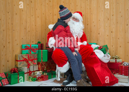 Un ragazzo in visita a Santa nella sua grotta di Natale. Foto Stock