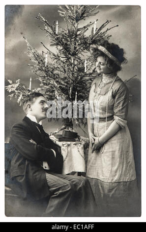 Felice coppia giovane celebrato con albero di natale. vintage foto con pellicola originale del grano e la sfocatura Foto Stock