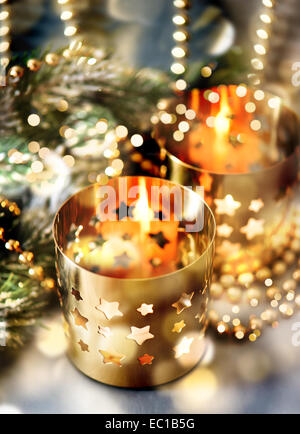 Decorazione natalizia con candele accese, lanterne e luci d'oro Foto Stock