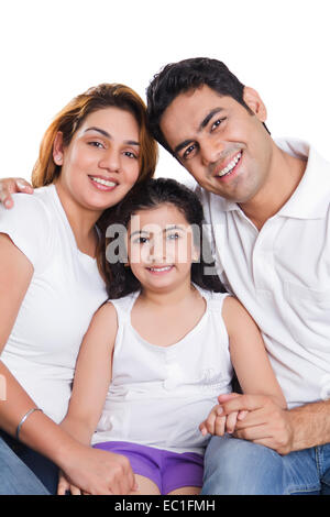 Indian genitori con bambino seduto a casa Foto Stock