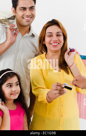 Indian genitori con bambino Shopping pagamento con carta di credito Foto Stock