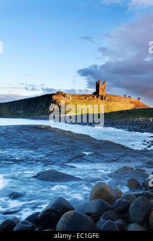 Il castello di Dunstanburgh al tramonto Northumberland Coast Inghilterra Foto Stock