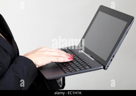 Le dita e le mani di una donna che utilizza un computer portatile Foto Stock