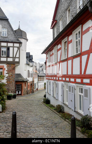 Stretta viuzza acciottolata con tipico tedesco case con travi di legno nella città vecchia di Geisenheim, Hesse, Germania, Europa Foto Stock