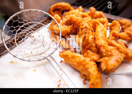 Croccante di pollo fritto offerte raffreddare su un tovagliolo di carta dopo essere stato cotto in una friggitrice. Foto Stock