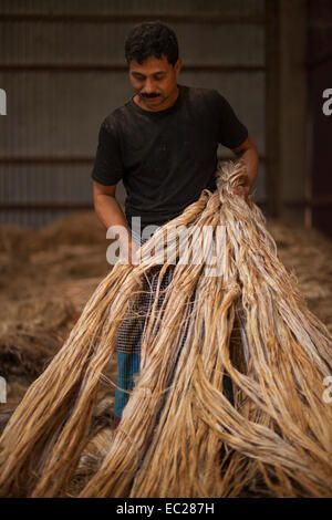 Dacca in Bangladesh. 08 dic 2014. Il lavoro del Bangladesh di lavorare all'interno di iuta godown Munshigonj nella periferia di Dhaka. Il Bangladesh è il più grande produttore mondiale di iuta, una sostanza fibrosa utilizzato nella realizzazione di tela ruvida, sacchi, stuoie, corda e spago e tappeto appoggiando. La iuta è un settore vitale da economico, agricolo, industriale e punto di vista commerciale in Bangladesh. Una volta la iuta è stato chiamato il "d'Oro" di fibra del Bangladesh. e la crescita di questo settore è in una condizione di vulnerabilità. Credito: zakir hossain chowdhury zakir/Alamy Live News Foto Stock