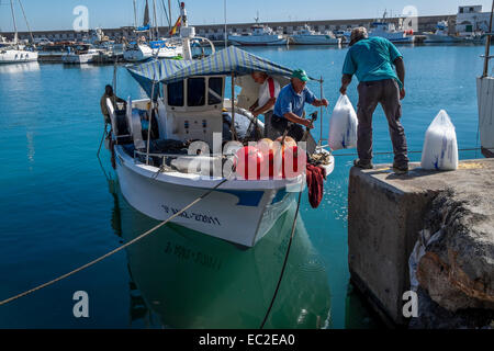 Caricamento del pescatore piccola barca da pesca con approvvigionamenti freschi prima di lasciare la porta su un viaggio di pesca Foto Stock