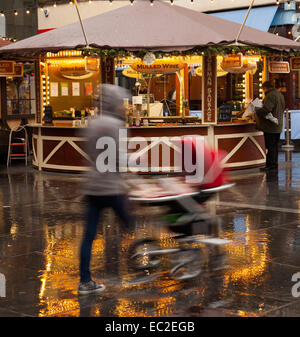 Dettaglianti che vendono vino brulé e salsicce in Chapel Street, Southport, Merseyside Regno Unito con tempo umido. Dopo i temporali nelle prime ore del resort costiero permane alta venti, guida sotto la pioggia e grandine, con sole intermittente. Foto Stock