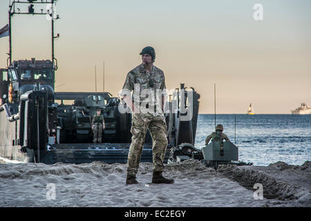 Gibilterra. 8 dicembre, 2014. Foto di veicoli pesanti, carri armati e mestieri trasferiti dalla spiaggia orientale di HMS baluardo appena fuori dalla spiaggia orientale. La Royal Navy flagship HMS baluardo arrivati a Gibilterra oggi lunedì mattina. Dopo una breve visita alla Baia di Gibilterra è intitolata al lato est della roccia. A partire dalla mattina si sono ancorate al largo di spiaggia orientale e ha iniziato a l effettuare alcuni trasferimenti in barca come parte di una formazione anfibio di esercizio che sarà condotta con RFA Lyme Bay, il Commandos da Charlie Company. Credito: Stephen Ignacio/Alamy Live News Foto Stock