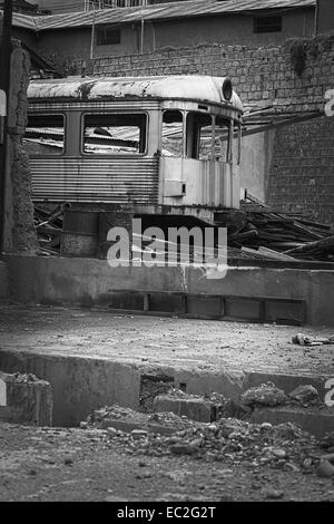 Vecchio arrugginito carro abbandonate tra permanente degli spessori di metallo e barili nel centro della città di La Paz in Bolivia Foto Stock