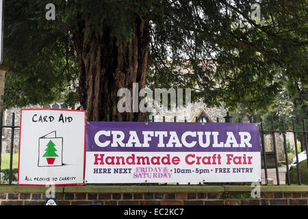 Banner attaccata alla chiesa di ringhiere pubblicità Carte di Natale e un 'handmade fiera artigianale". Foto Stock