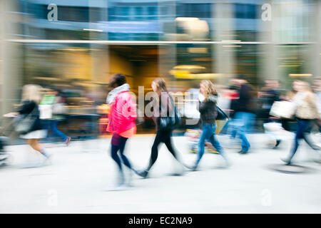 Una shopper oltrepassando una finestra del negozio Foto Stock