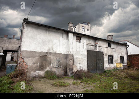 Sullen magazzino abbandonato con cielo tempestoso. Foto Stock