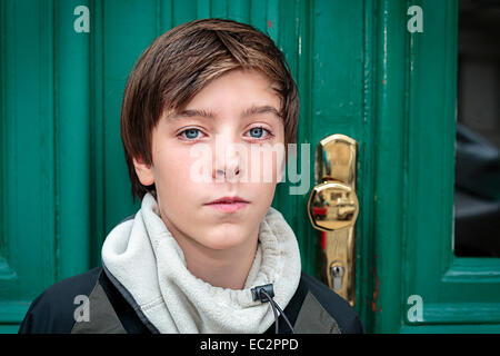 Ritratto di un bel ragazzo adolescente di fronte ad una porta verde Foto Stock