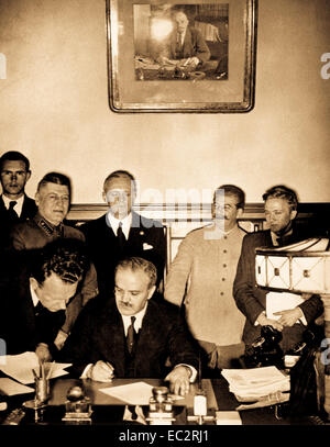 Il ministro degli esteri sovietico molotov segni il tedesco-sovietica patto nonaggression; Joachim von Ribbentrop e Josef Stalin stare dietro di lui, Mosca, 23 agosto 1939 Foto Stock