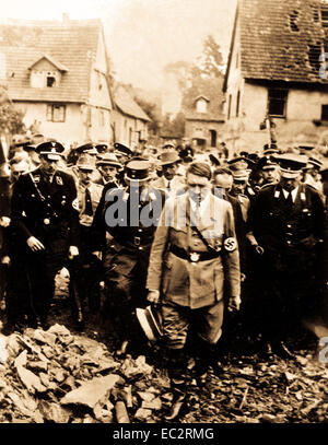 Adolf Hitler, accompagnato da altri funzionari tedeschi, cupamente ispeziona i danni della bomba in una città tedesca nel 1944, in questo film tedesco catturato dalla US Army Signal Corps sul fronte occidentale. ca. 1944. (Esercito) Foto Stock