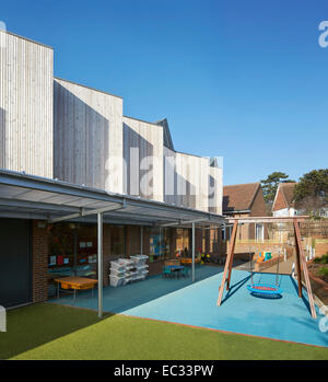 Hollymount School di Londra, Regno Unito. Architetto: Haverstock Associates LLP, 2013. Prospettiva di facciata con parco giochi e co Foto Stock