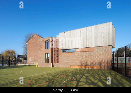 Hollymount School di Londra, Regno Unito. Architetto: Haverstock Associates LLP, 2013. Costruzione di elevazione dal campo sportivo. Foto Stock