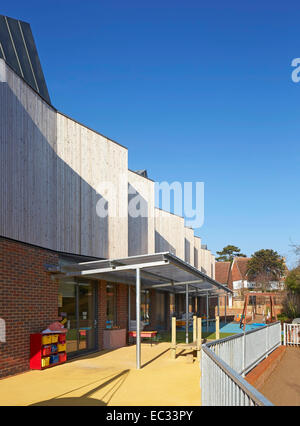 Hollymount School di Londra, Regno Unito. Architetto: Haverstock Associates LLP, 2013. Prospettiva di facciata con parco giochi e co Foto Stock