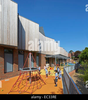 Hollymount School di Londra, Regno Unito. Architetto: Haverstock Associates LLP, 2013. Prospettiva di facciata con parco giochi e ch Foto Stock