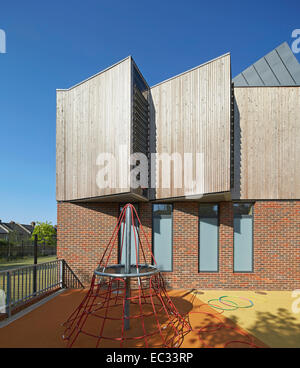 Hollymount School di Londra, Regno Unito. Architetto: Haverstock Associates LLP, 2013. Particolare della facciata esterna con parco giochi per bambini Foto Stock