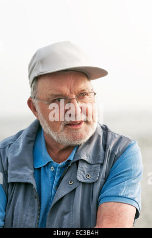 Ritratto di sorridendo felice uomo senior all'aperto che guarda lontano Foto Stock