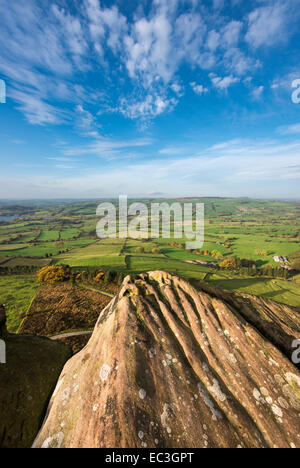 Rocce di pietra calcarea intemperie sulla cima di Hen Cloud (le Roaches) con vista attraverso un paesaggio di patchwork sotto. Foto Stock