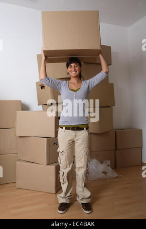 Giovane donna recante una scatola di movimentazione Foto Stock