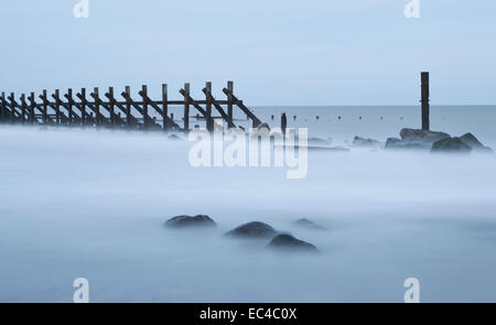 In legno e roccia mare difese a Happisburgh, Norfolk, Inghilterra, Regno Unito Foto Stock