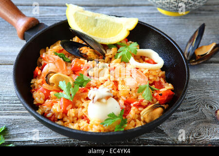 La paella con riso e frutti di mare in una padella, cibo close up Foto Stock