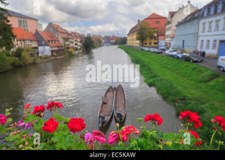 Fiume, barche, fiori di colore rosso e case vintage a Bamberg in Germania Foto Stock