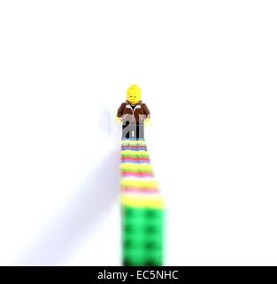 Lego figura e lego scale. In aumento. Sorridente in difficoltà. Foto Stock