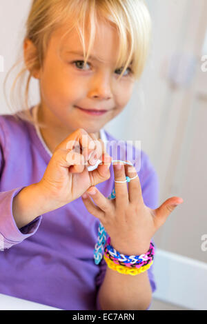 Ritratto di bambina rendendo telaio bracciali Foto Stock