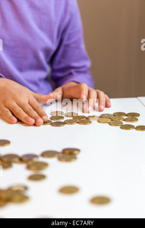 Bambina contando pocket money Foto Stock