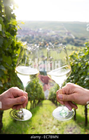 In Germania, in Baviera, Volkach, bicchieri tintinnanti nel vigneto Foto Stock