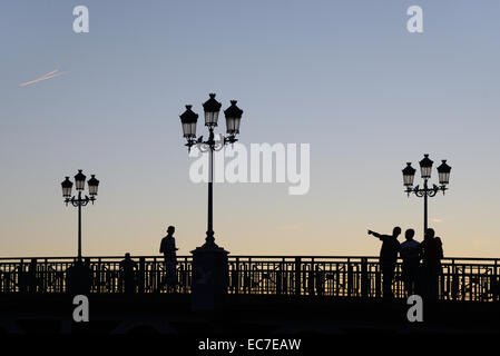 Sera sagome delle lampade stradali & Persone sul Pont St Pierre ponte sopra il fiume Garonne Toulouse Haute Garonne Francia Foto Stock