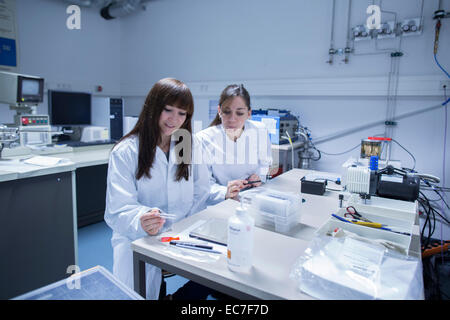 Due femmina technicans lavorando insieme in un laboratorio tecnico Foto Stock