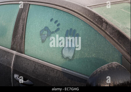 Stampa a mano come piedi stampe frost fuso sulla finestra per auto idea di intrappolato all'interno di sopravvivere in caso di ondata di freddo chiamata per aiutare a sunrise Foto Stock