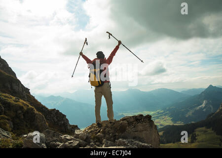 Austria, Tirolo, Tannheimer Tal, giovane donna con escursioni poli tifo sulla cima della montagna Foto Stock