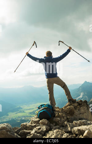 Austria, Tirolo, Tannheimer Tal, giovane con escursioni poli tifo sulla cima della montagna Foto Stock