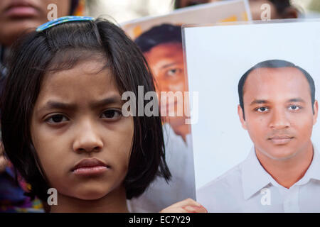 Dacca in Bangladesh. 10 dicembre, 2014. Famiy deputati hanno fatto catena umana tenendo le immagini dei loro parenti scomparsi durante la celebrazione della Giornata Internazionale dei Diritti Umani a Dhaka. Secondo l organizzazione dei diritti di Odhikar ha dichiarato che 150 persone, per la maggior parte da politici sfondi, cadde vittima di sparizione forzata tra gennaio 2009 e agosto 2014. Credito: zakir hossain chowdhury zakir/Alamy Live News Foto Stock