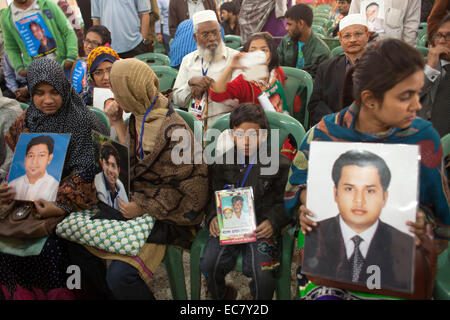 Dacca in Bangladesh. 10 dicembre, 2014. Famiy deputati hanno fatto catena umana tenendo le immagini dei loro parenti scomparsi durante la celebrazione della Giornata Internazionale dei Diritti Umani a Dhaka. Secondo l organizzazione dei diritti di Odhikar ha dichiarato che 150 persone, per la maggior parte da politici sfondi, cadde vittima di sparizione forzata tra gennaio 2009 e agosto 2014. Credito: zakir hossain chowdhury zakir/Alamy Live News Foto Stock