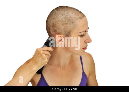 La donna in viola corpetto la rasatura stessa calvo con clipper, isolato su bianco. Composizione orizzontale. Foto Stock