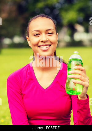 Sorridente ragazza adolescente che mostra la bottiglia Foto Stock