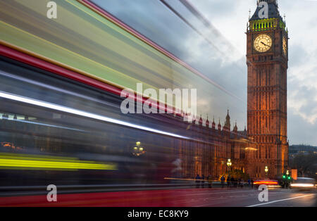 Bus rosso che passa di fronte al Big Ben e le Camere del Parlamento a Londra, Inghilterra, Regno Unito Foto Stock