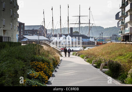 La passerella davanti ai moderni appartamenti fino a Bristol il floating harbour con Brunel SS Gran Bretagna liner in bacino di carenaggio sulla riva lontana Foto Stock