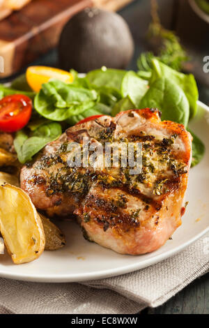 Grandi braciole di maiale alla griglia con basilico Condimento al limone Foto Stock